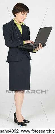 Woman holding a laptop View Large Photo Image Stock Image - Woman holding a laptop . Fotosearch