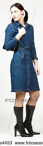 Woman in blue denim dress with black purse View Large Photo Image Stock Image - Woman in blue denim dress with black purse. Fotosearch