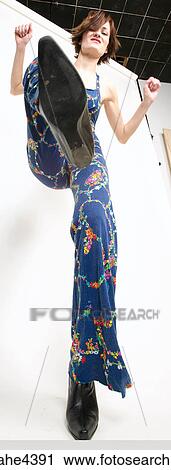 Stock Image - Woman in blue outfit kicking her foot. Fotosearch