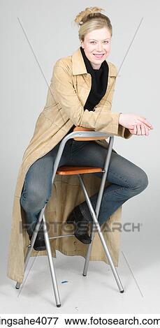 Woman sitting on a high chair View Large Photo Image Stock Photo - Woman sitting on a high chair . Fotosearch