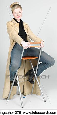 Stock Photograph - Woman sitting on a high chair . Fotosearch