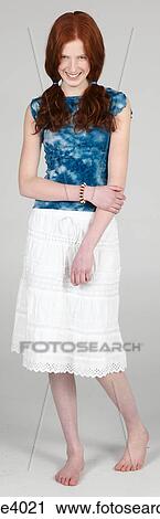 Stock Image - Woman standing shyly and smiling . Fotosearch
