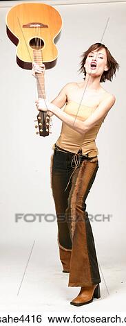 Woman swinging acoustic guitar over her head View Large Photo Image Stock Photograph - Woman swinging acoustic guitar over her head. Fotosearch
