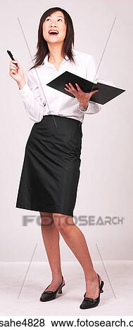 Young Asian business woman holding a notebook and gesturing with her pen View Large Photo Image Stock Photo - Young Asian business woman holding a notebook and gesturing with her pen. Fotosearch
