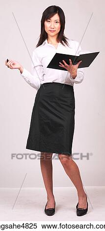 Young Asian business woman holding a notebook and a pen View Large Photo Image Stock Photography - Young Asian business woman holding a notebook and a pen. Fotosearch