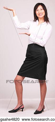 Young Asian business woman making a hand gesture to the side View Large Photo Image Stock Image - Young Asian business woman making a hand gesture to the side. Fotosearch