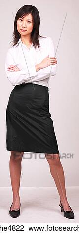 Young Asian business woman standing with her arms crossed in front of her View Large Photo Image Stock Image - Young Asian business woman standing with her arms crossed in front of her. Fotosearch