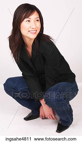 Young Asian woman crouched down on her heels View Large Photo Image Stock Image - Young Asian woman crouched down on her heels. Fotosearch