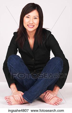 Young Asian woman sitting cross legged on the floor View Large Photo Image Stock Photo - Young Asian woman sitting cross legged on the floor. Fotosearch