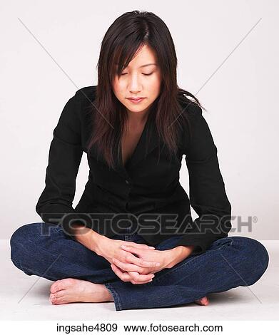 Young Asian woman sitting cross legged on the floor View Large Photo Image Stock Photo - Young Asian woman sitting cross legged on the floor . Fotosearch
