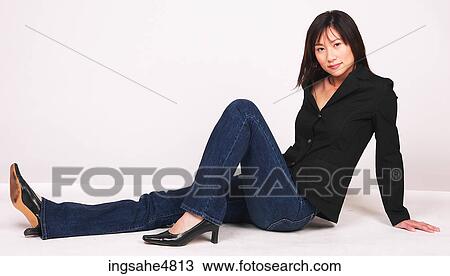 Young Asian woman sitting on the floor with her legs out in front of her View Large Photo Image Stock Image - Young Asian woman sitting on the floor with her legs out in front of her . Fotosearch