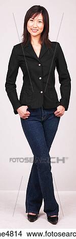 Picture - Young Asian woman standing with her hands in her pockets. Fotosearch