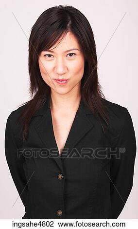 Young Asian woman standing with her hands behind her back View Large Photo Image Stock Image - Young Asian woman standing with her hands behind her back. Fotosearch