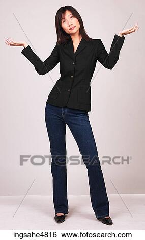 Stock Photograph - Young Asian woman standing with her hands out by her shoulders . Fotosearch