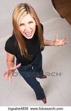 Young blond woman making an angry expression View Large Photo Image Stock Photo - Young blond woman making an angry expression . Fotosearch