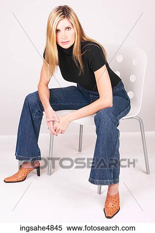 Young blonde woman sitting on a chair View Large Photo Image Stock Photography - Young blonde woman sitting on a chair. Fotosearch