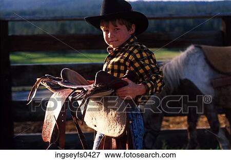 Cowboy Holding Saddle View Large Photo Image Stock Photo - Cowboy Holding Saddle. Fotosearch