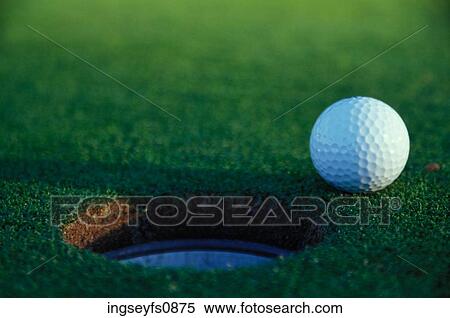 Golf Ball Poised at Edge of Hole View Large Photo Image Stock Photography - Golf Ball Poised at Edge of Hole. Fotosearch