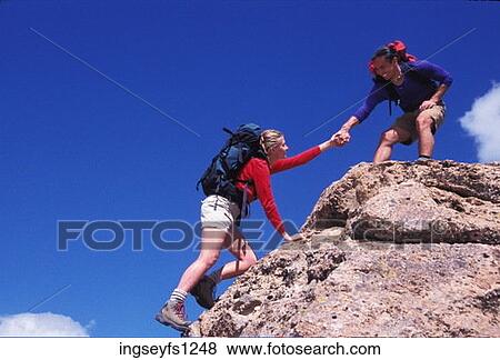 Stock Photo - Man and Woman Rock Climbing. Fotosearch
