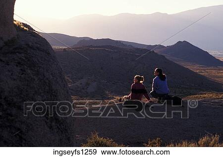 Stock Photo - Man and Woman Sitting on Rock Together. Fotosearch