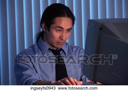 Stock Image - Man Working Late At Office. Fotosearch