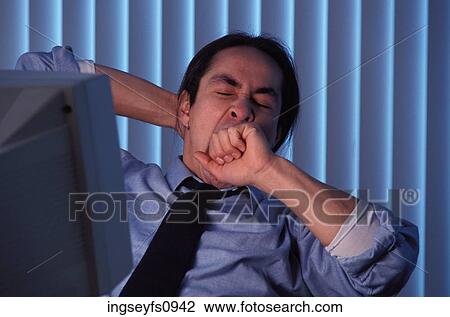 Stock Image - Sleepy Man Working Late at Office. Fotosearch