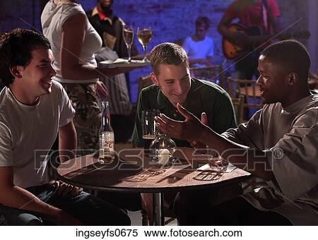 Three Young Men Chatting at a Bar View Large Photo Image Stock Photography - Three Young Men Chatting at a Bar. Fotosearch