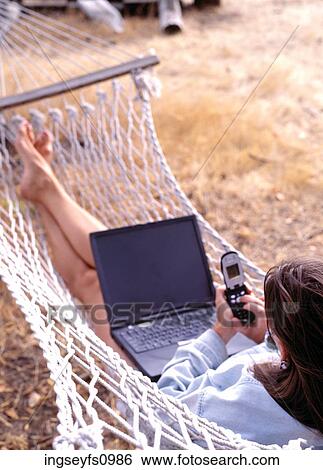 Woman Using Cell Phone and Laptop View Large Photo Image Stock Photograph - Woman Using Cell Phone and Laptop. Fotosearch