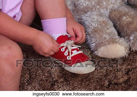 Stock Image - Young Girl Tying Shoe. Fotosearch