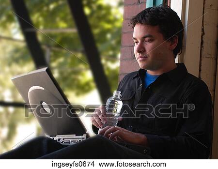 Young Man Typing at a Windowsill View Large Photo Image Picture - Young Man Typing at a Windowsill. Fotosearch