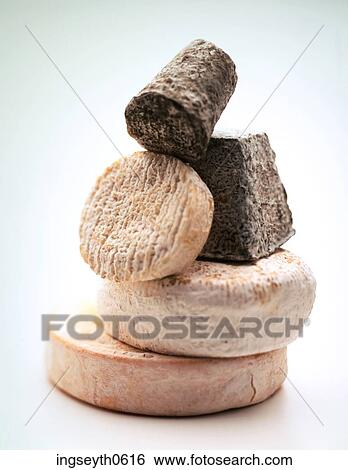 Stock Photograph - Cheese, cheeses, cheese selection, piled cheese, cheese board, brie, goats cheese. Fotosearch