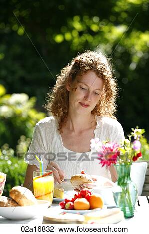 A beautiful woman eating a meal in her garden View Large Photo Image Stock Image - A beautiful woman eating a meal in her garden. Fotosearch