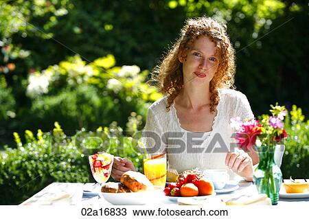 A beautiful woman eating a meal in her garden View Large Photo Image Stock Image - A beautiful woman eating a meal in her garden. Fotosearch