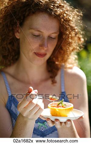 A beautiful woman eating an orange View Large Photo Image Stock Photo - A beautiful woman eating an orange. Fotosearch
