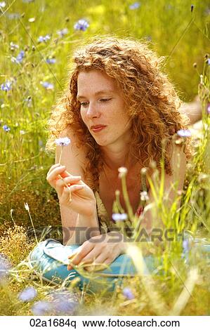Stock Photography - A beautiful woman lying in a field of flowers. Fotosearch