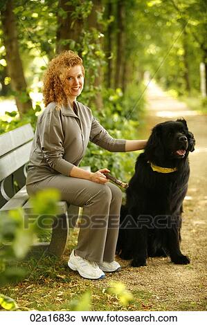 Stock Image - A beautiful woman with her dog. Fotosearch