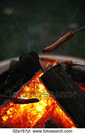 A sausage being cooked on a fire View Large Photo Image Stock Photograph - A sausage being cooked on a fire. Fotosearch