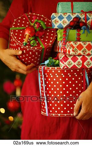 A woman holding Christmas presents View Large Photo Image Stock Photograph - A woman holding Christmas presents. Fotosearch