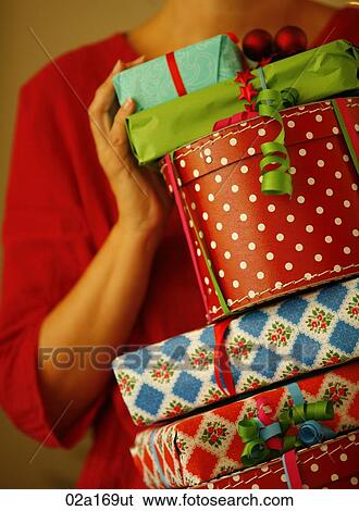 Stock Photograph - A woman holding Christmas presents. Fotosearch