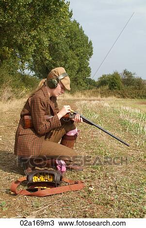 Stock Image - A woman loading a gun. Fotosearch