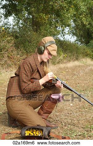 Stock Photograph - A woman loading a gun. Fotosearch
