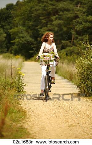 Picture - A woman riding a bike. Fotosearch