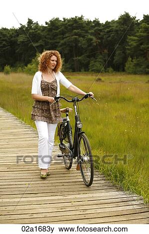 A woman with a bike View Large Photo Image Stock Photo - A woman with a bike. Fotosearch