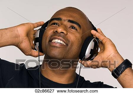 African-American man listening to music on head phones. View Large Photo Image Stock Photo - African-American man listening to music on head phones.. Fotosearch
