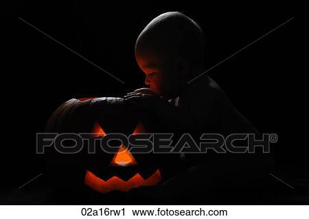Baby looking into a lit up pumpkin at halloween View Large Photo Image Stock Image - Baby looking into a lit up pumpkin at halloween. Fotosearch