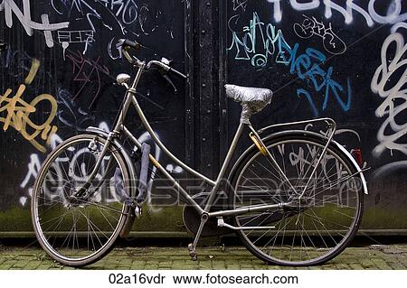 Bicycle parked by graffiti wall View Large Photo Image Stock Photography - Bicycle parked by graffiti wall. Fotosearch