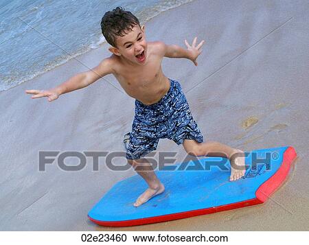 Boy on boogie board at the beach. View Large Photo Image Stock Image - Boy on boogie board at the beach.. Fotosearch