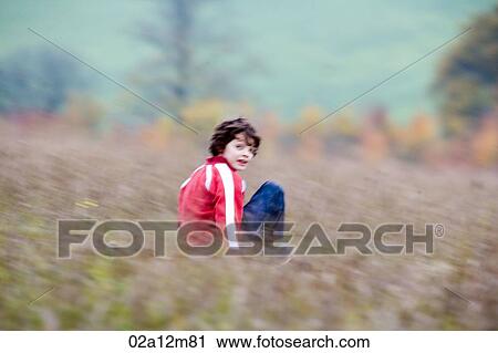 Boy riding a mountain board in a field View Large Photo Image Stock Image - Boy riding a mountain board in a field. Fotosearch