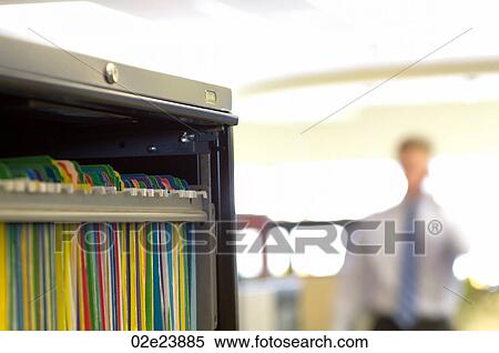 Stock Photography - Business man talking on cell phone in office.. Fotosearch