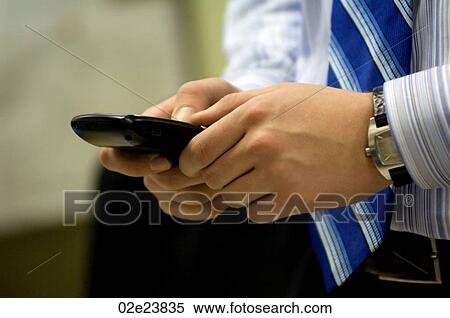 Stock Photography - Business man using PDA in office.. Fotosearch
